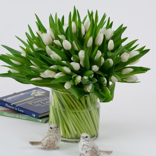 Elegant white tulip bouquet in a clear glass vase with decorative birds from a luxury florist Cary